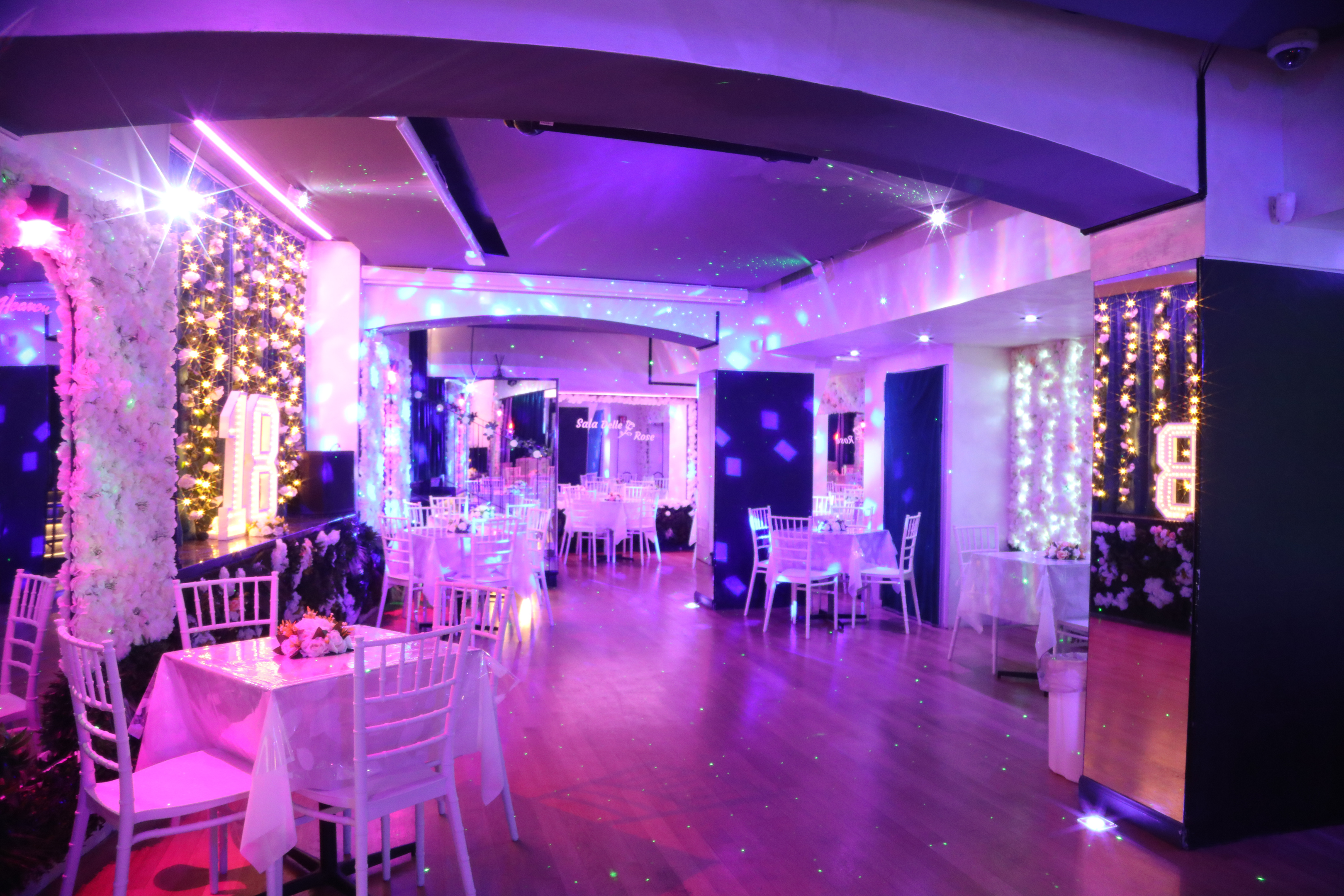 Allestimento della sala con tavoli trasparenti e luci viola e magenta